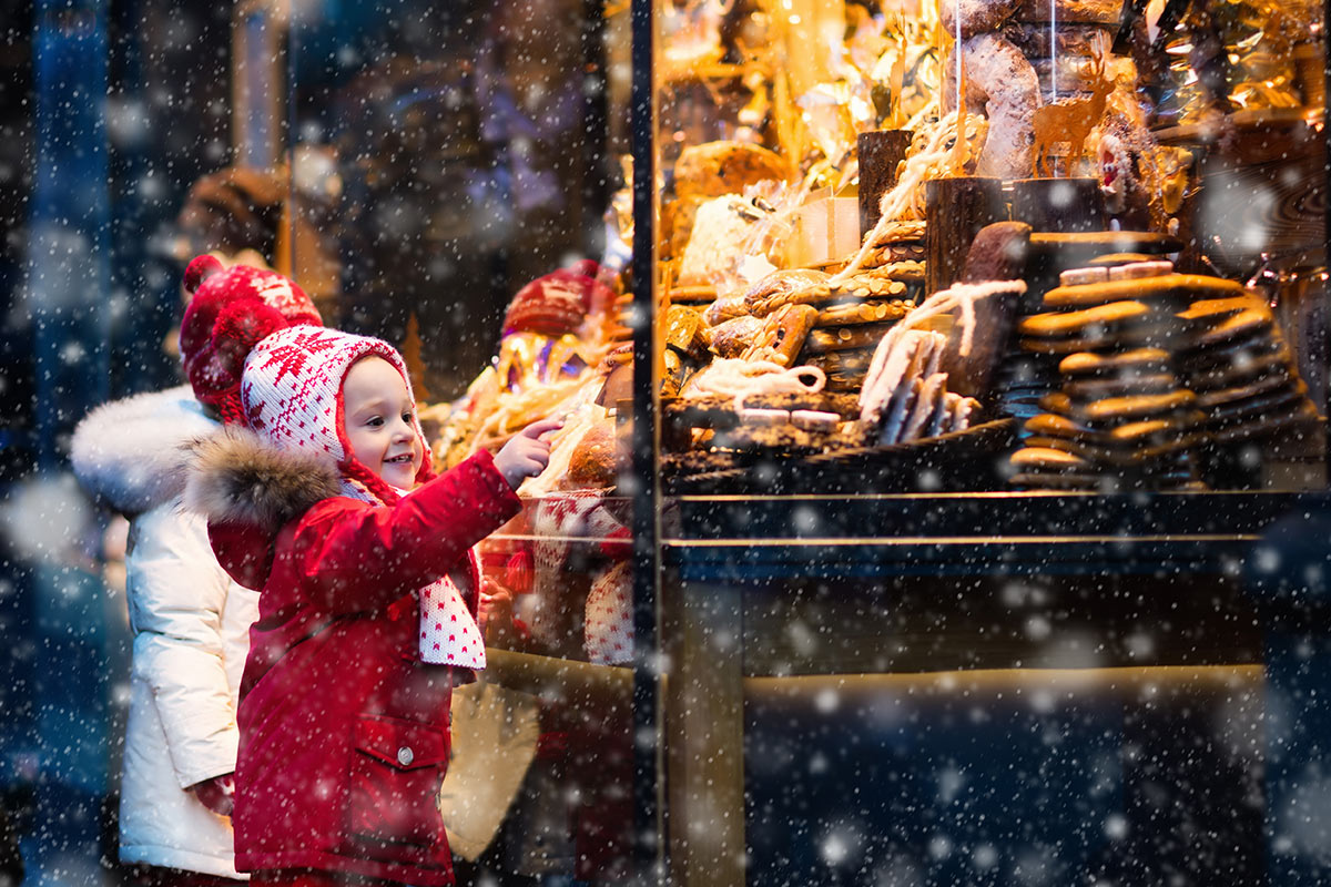 A toddler enjoys a cheerful Christmas market stall
