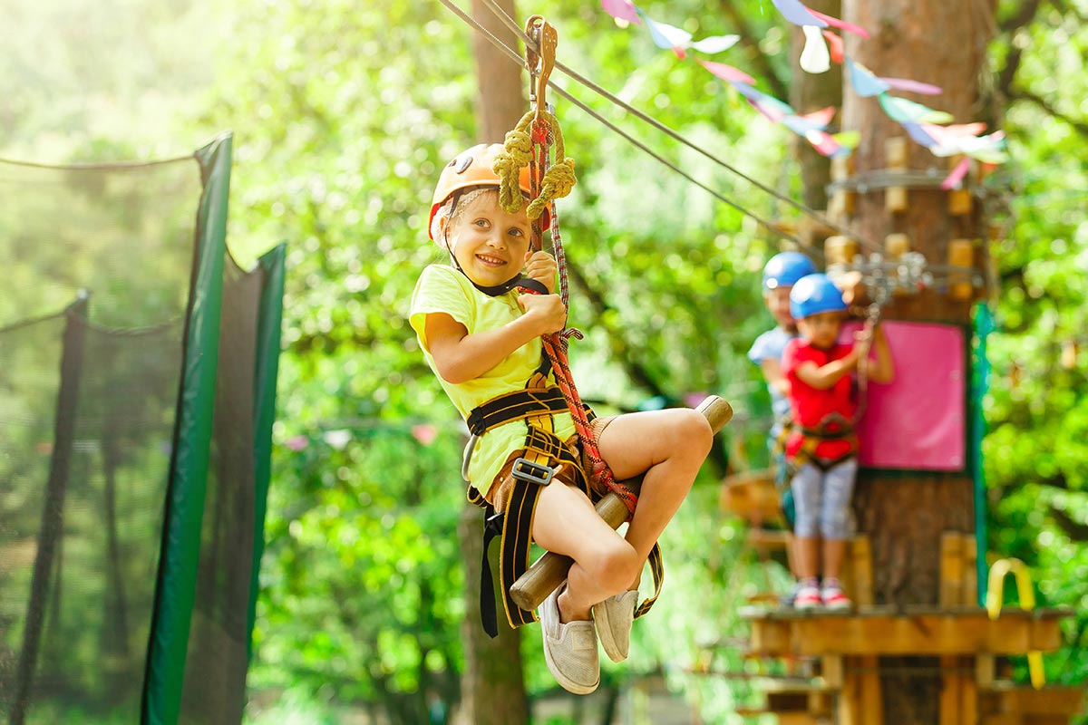 A girl on a zip line in the trees