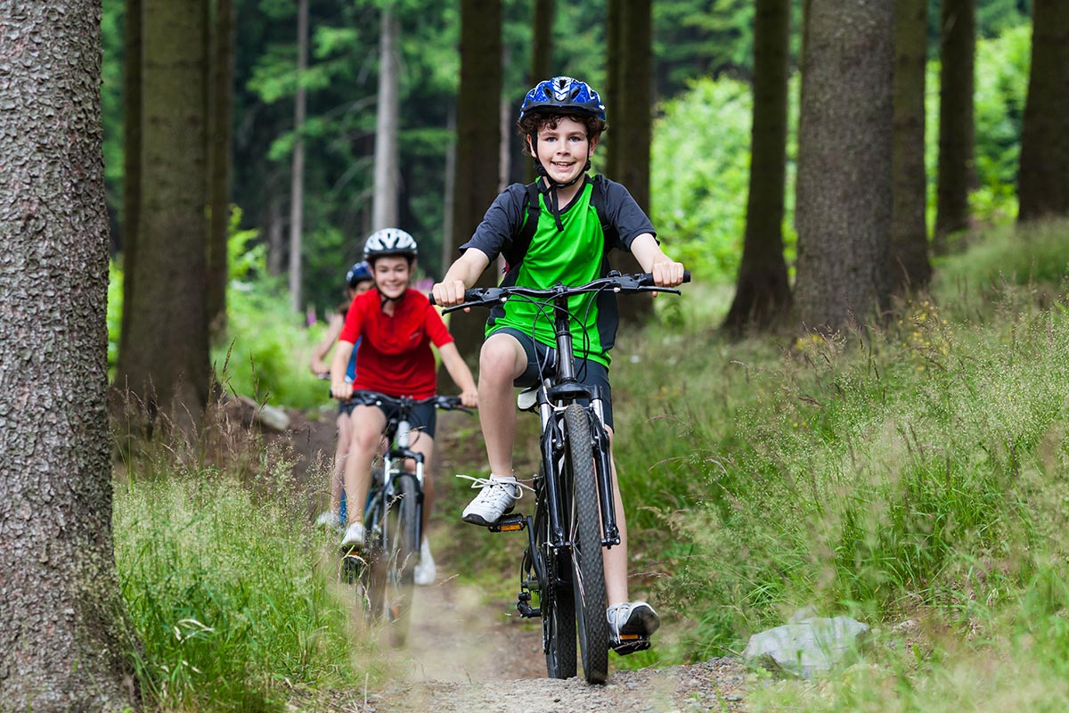 Kids cycle in the woods