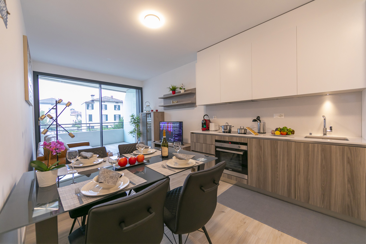 Una cucina elegante e completamente attrezzata con sala da pranzo nella casa vacanze Enchanted Home, Lugano.