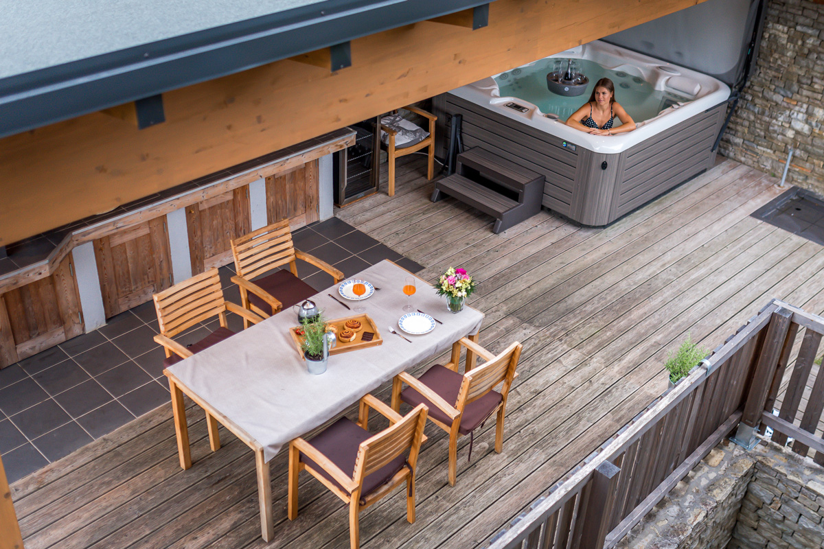 Una terrazza in legno per cene all'aperto per 4 persone e una vasca idromassaggio nello Chalet Wellness di Happy.Rentals in Slovenia