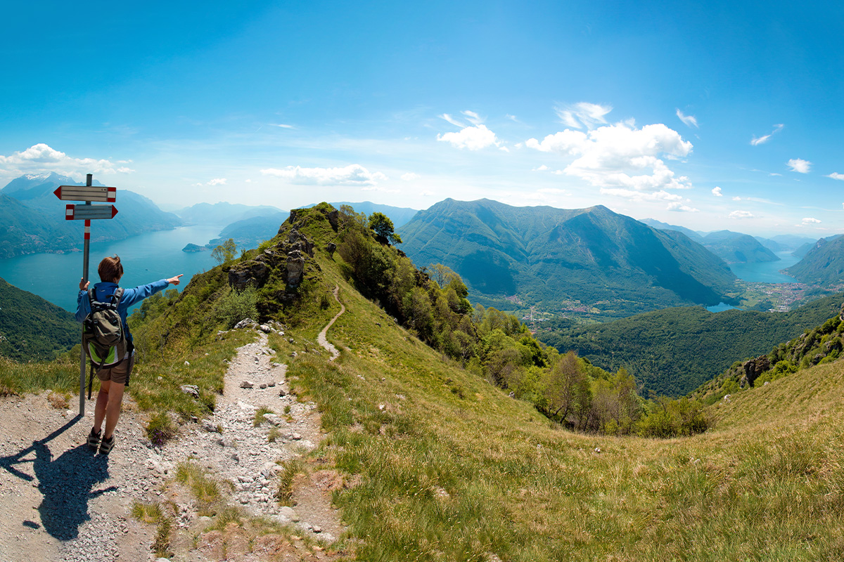 Un escursionista si gode la splendida vista panoramica del Lago di Como e del Lago di Lugano dal Pizzo Coppa, Menaggio