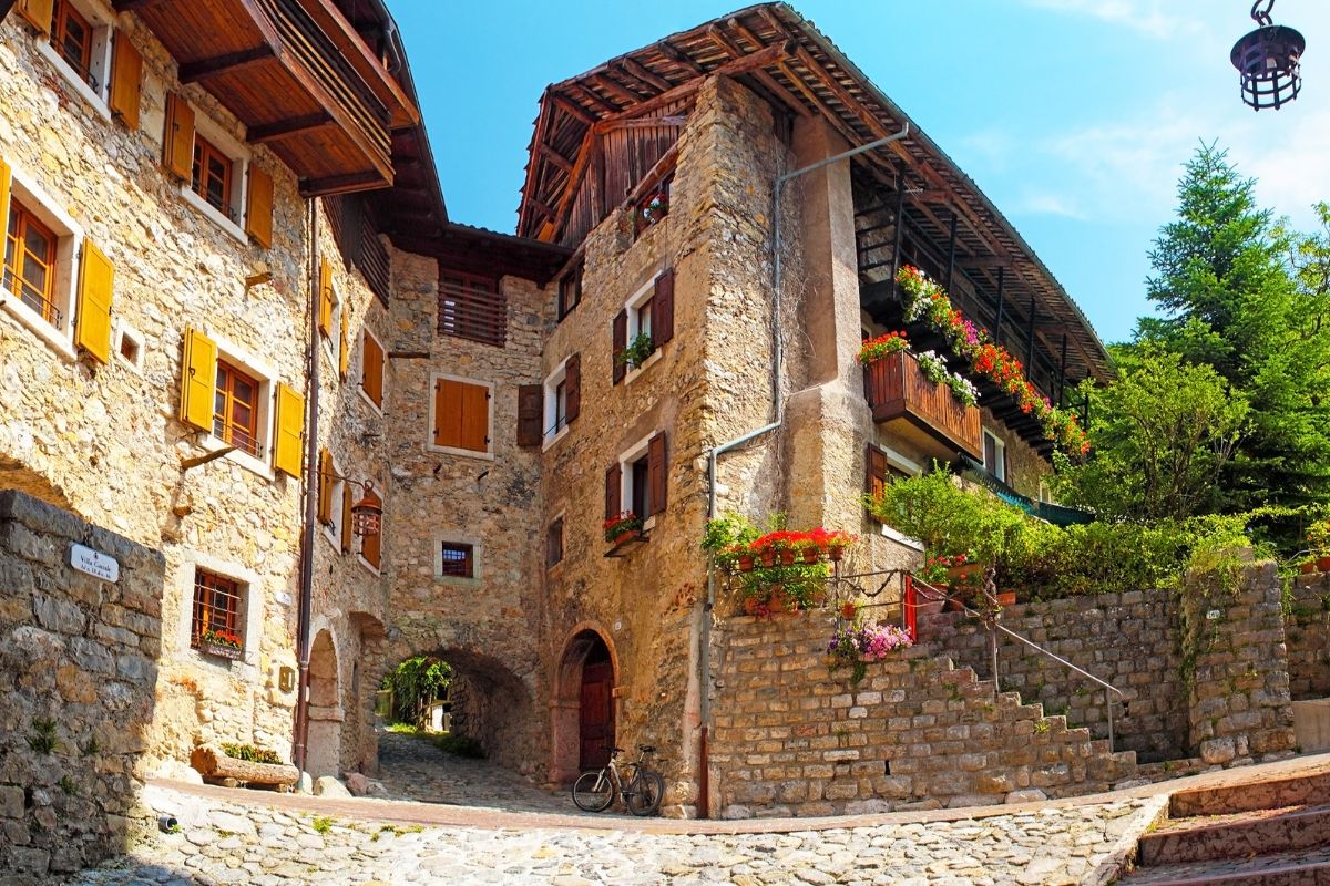 The atmospheric cobblestone streets and buildings at Canale di Tenno, with flowered balconies