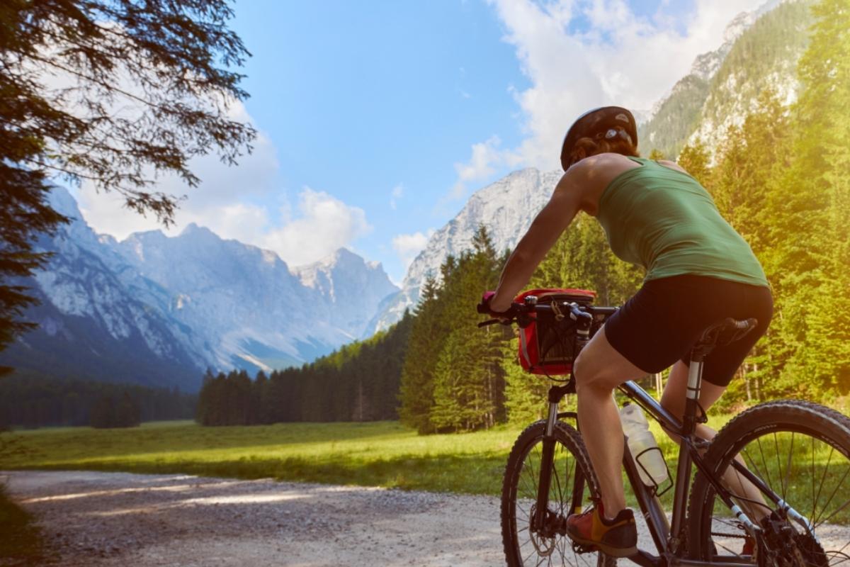 Una ciclista percorre la ramificata rete ciclabile slovena, circondata dalle montagne e dal verde alpino