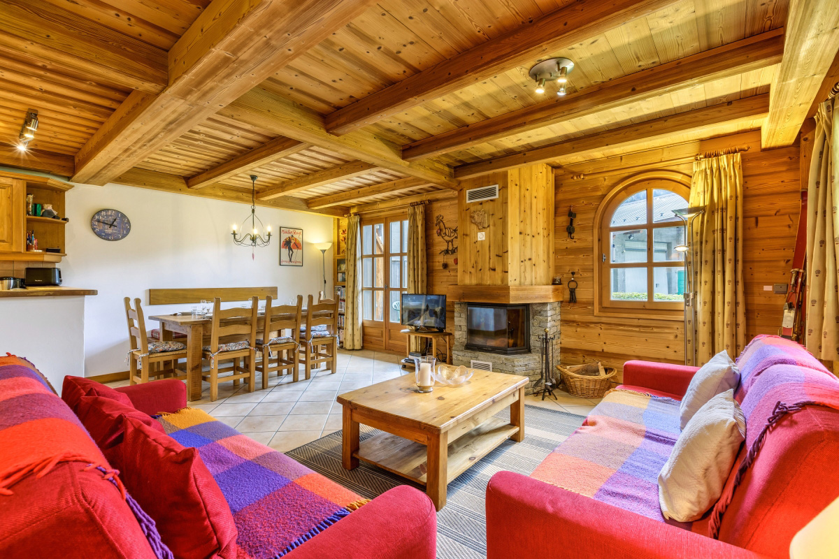 Uno spazioso soggiorno con molti posti a sedere e un camino con parafuoco per momenti perfetti con la famiglia, presso la proprietà ID 6041 di Happy.Rentals a Chamonix, Francia