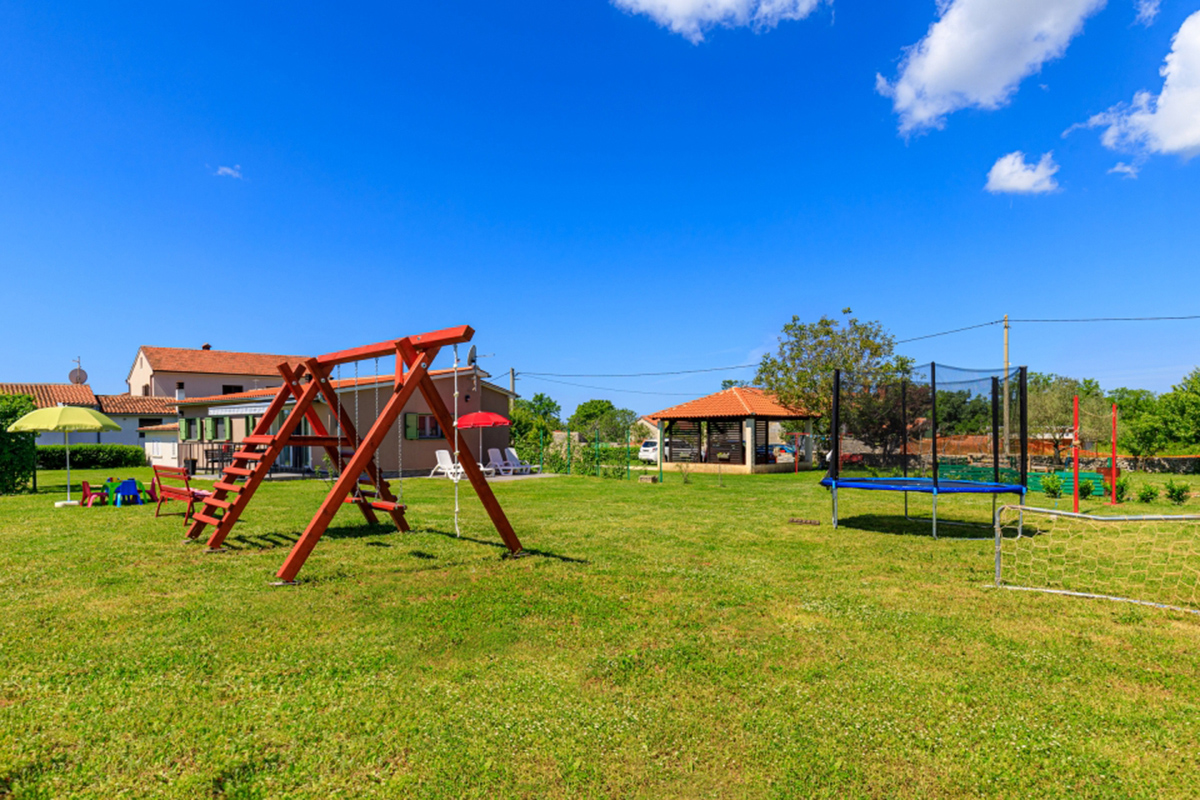 Casa vacanze adatta ai bambini in Croazia, con un grande giardino con area giochi attrezzata con altalene e trampolino. Happy Rentals ID struttura 4384