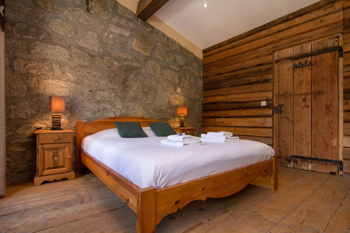 The cosy bedroom of Chalet Glacier with nature-inspired wood and stone interiors, located in Chamonix, France (Happy.Rentals ID: 4097) 