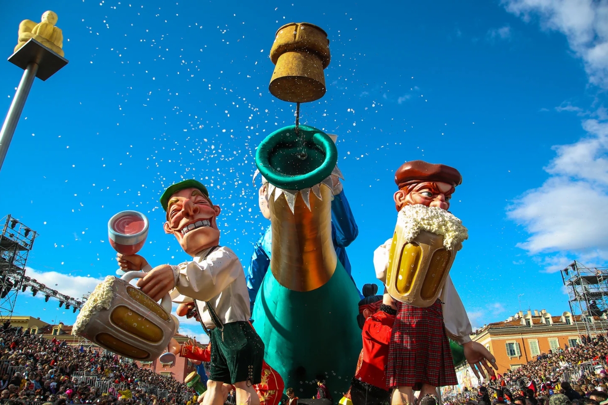 A carnival float decorated with papier-mâché dolls and surrounded by confetti in Nice, France