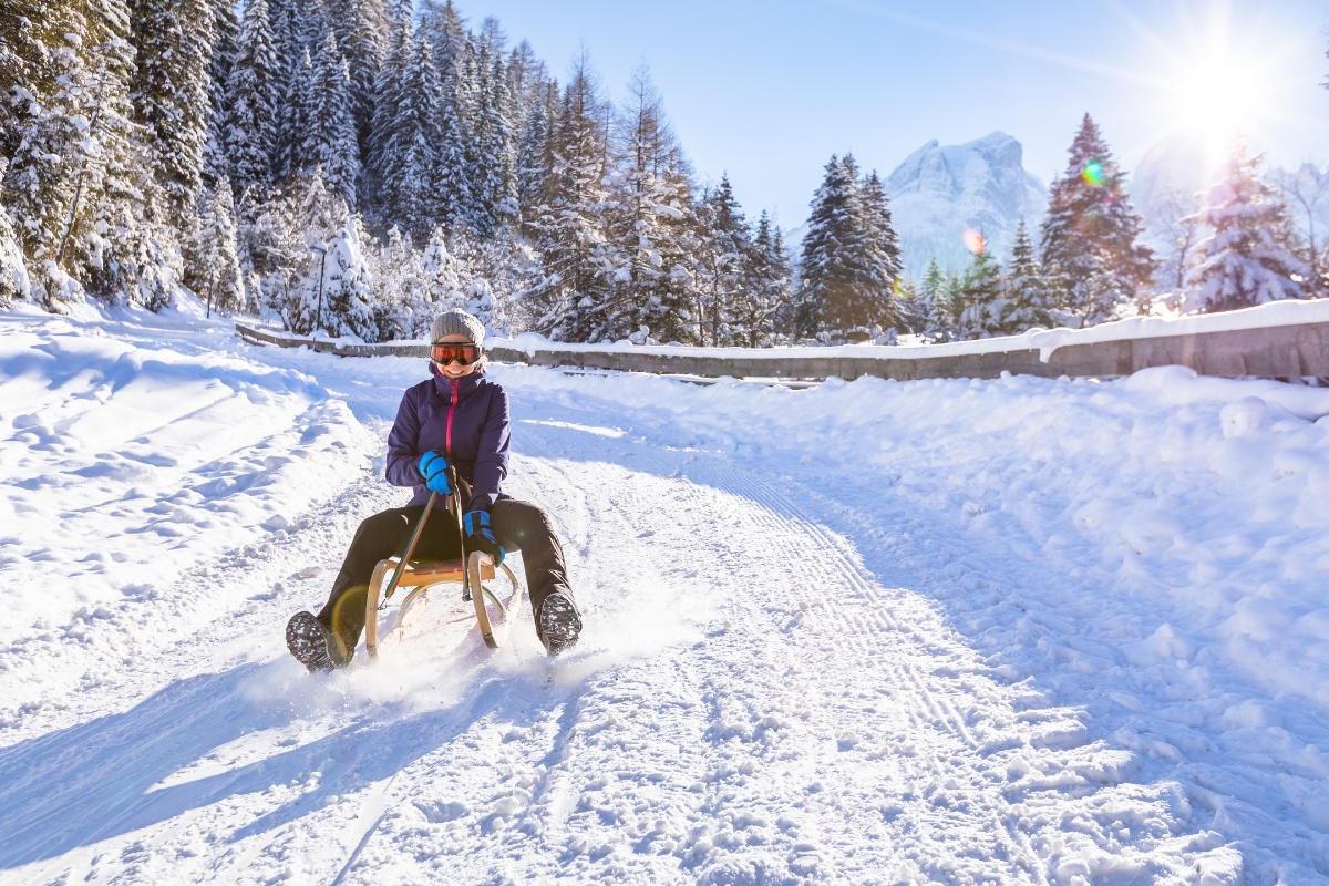 young woman sledding on a trail