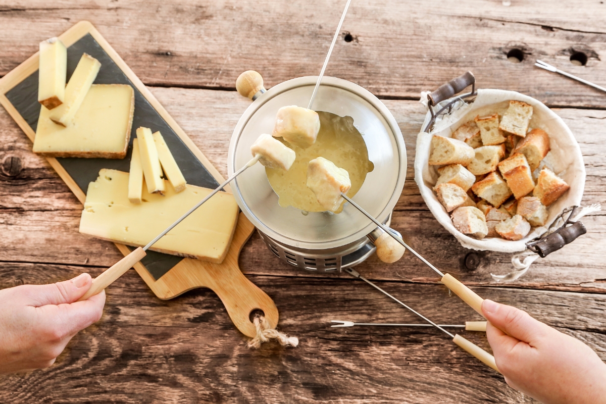 Specialità francese, fonduta di formaggio con set per fonduta, pane raffermo e una selezione di formaggi