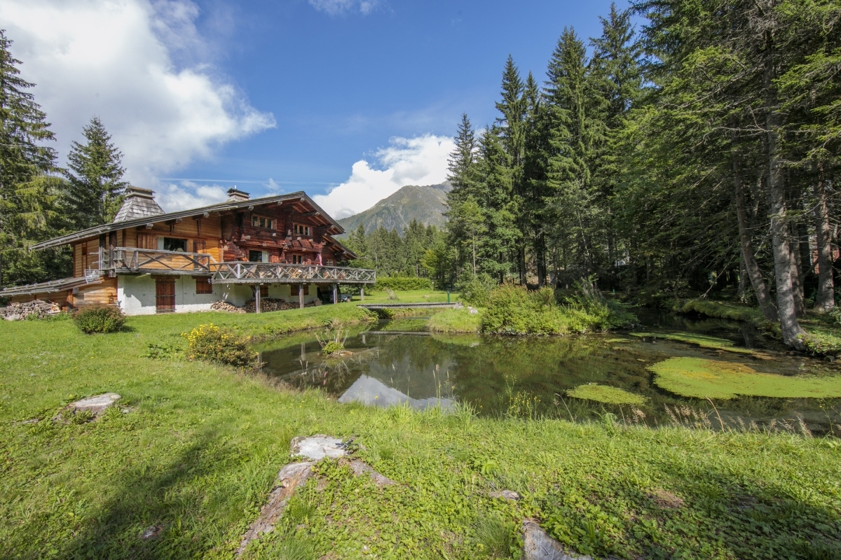 Happy.Rentals property chalet Tré La Vieux surrounded by mountains and trees with a lake on the front
