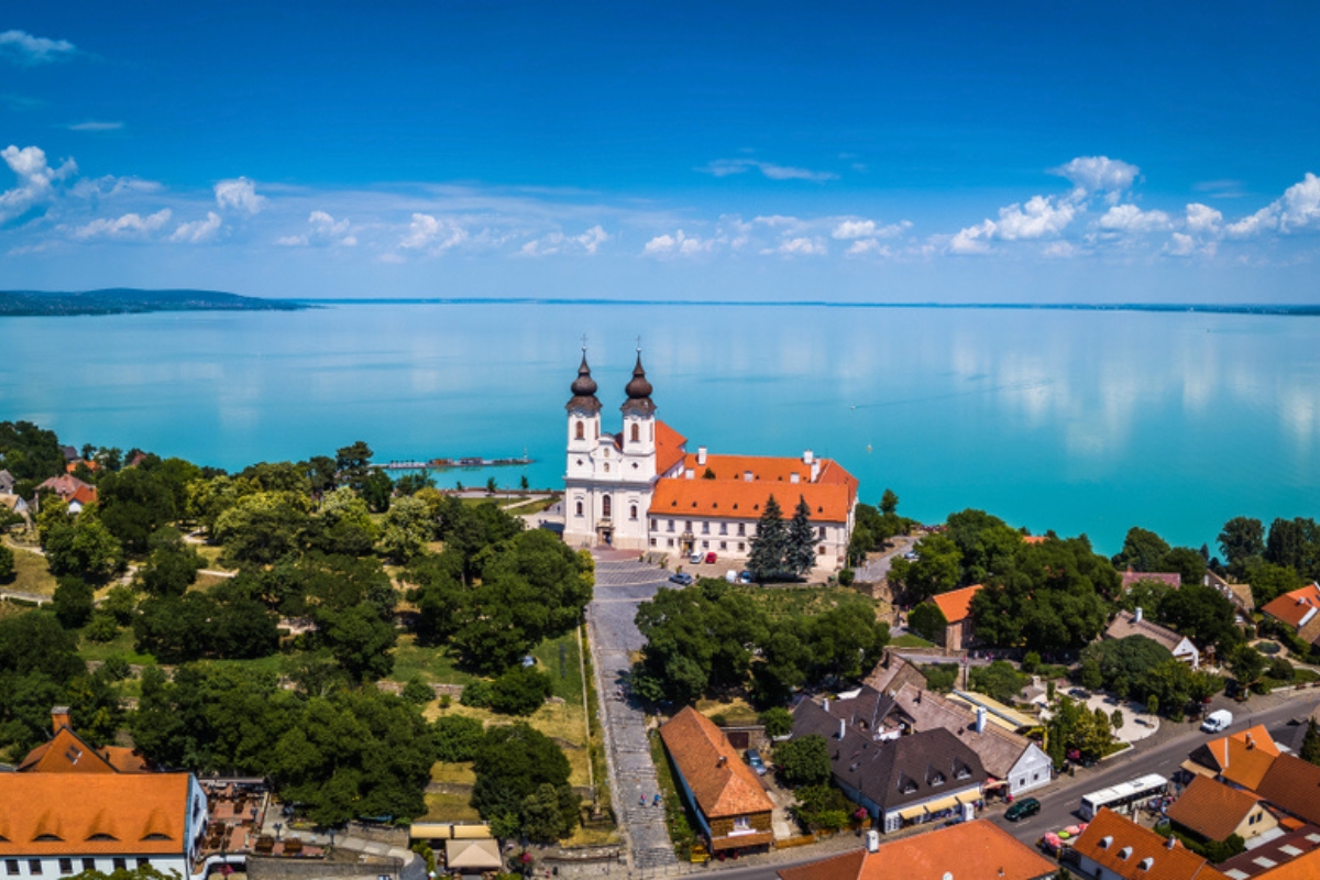 Tihany, Ungheria - Vista aerea panoramica del famoso monastero benedettino di Tihany (Abbazia di Tihany) con il bellissimo e colorato lago Balaton sullo sfondo