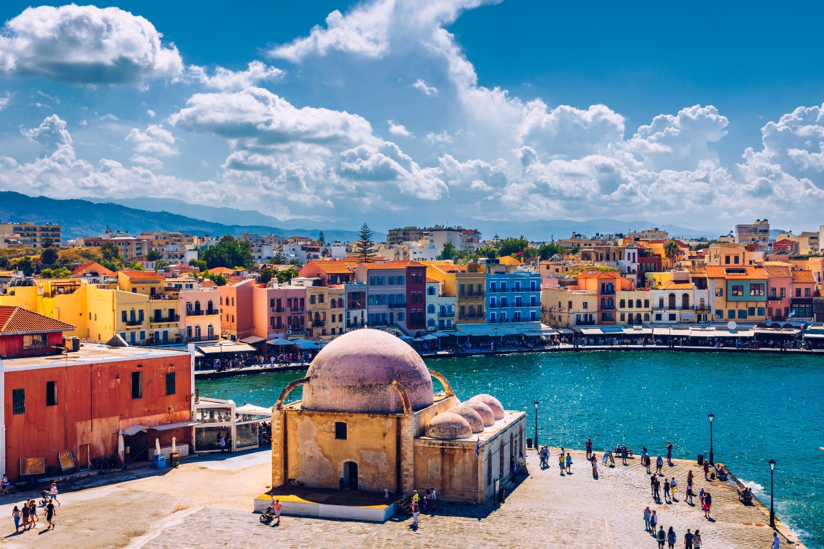 Chania’s harbour surrounded by colorful houses and clear waters with the Küçük Hasan Mosque in the foreground, Crete