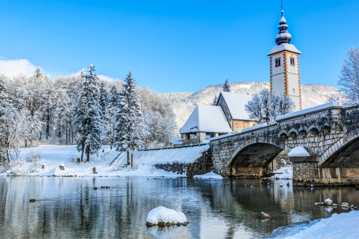Church of Sv. John the Baptist and a bridge by the Bohinj lake in winter, Slovenia