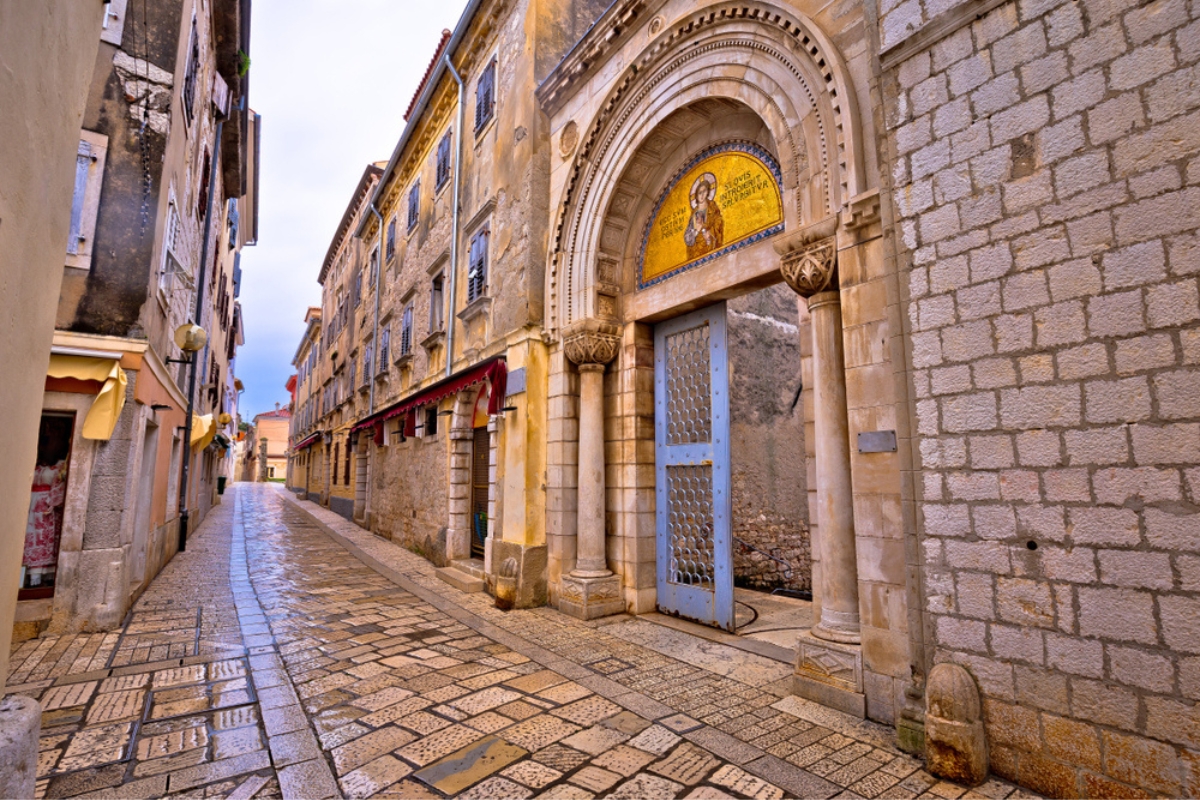 Euphrasian Basilica gate and Porec stone street view, UNESCO world heritage site in Istria, Croatia 