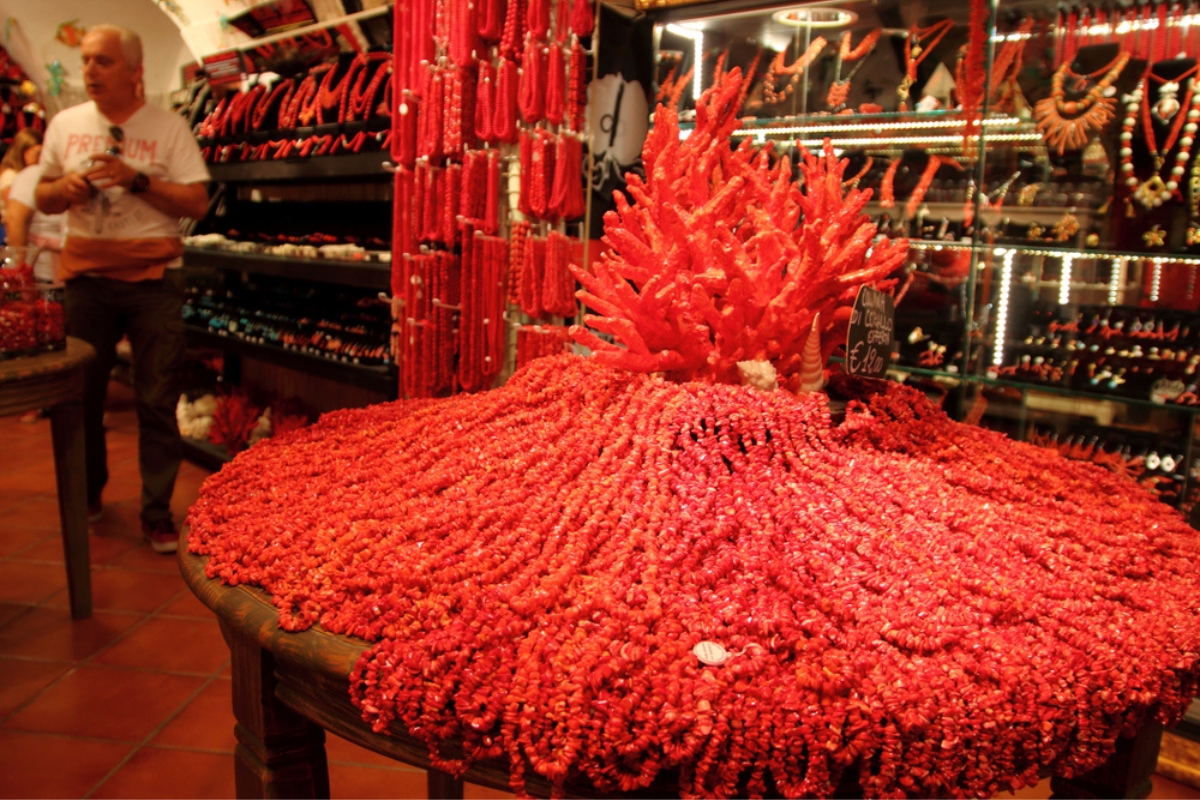 Gioielli di corallo venduti per i turisti in un negozio locale, nel centro storico di Alghero, Sardegna