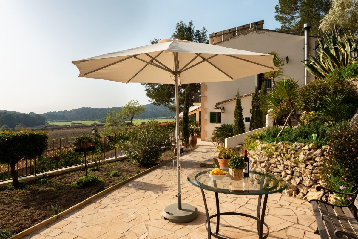 Big terrace with sunshade in the countryside with solar panels on the roof in the background