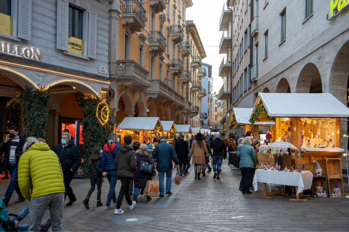 I vivaci mercatini di Natale di Lugano, in Svizzera, con le suggestive bancarelle in legno e i turisti