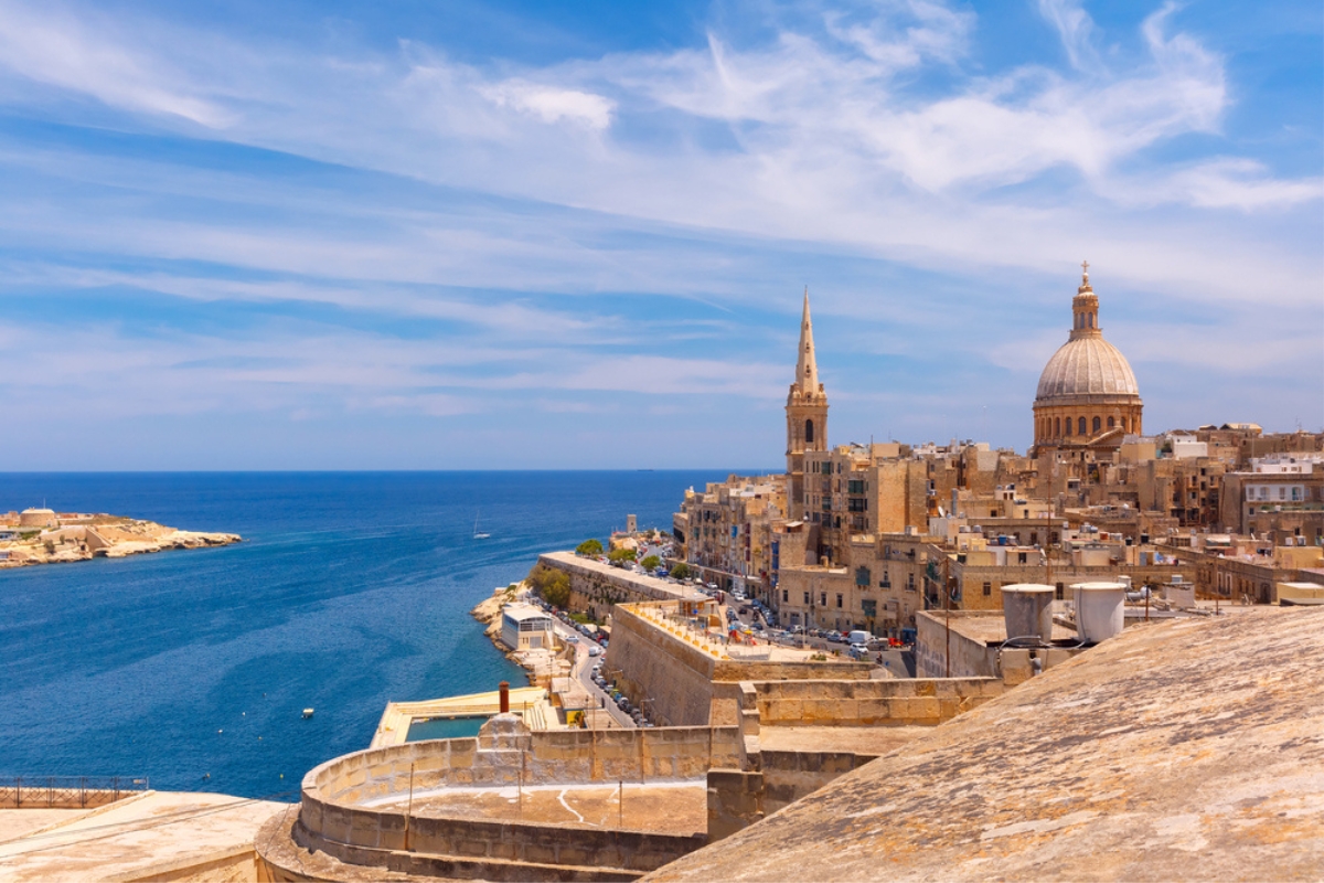 Il centro storico dorato di La Valletta sul mare blu di Malta, con la cupola dorata della Cattedrale di San Paolo che punteggia lo skyline