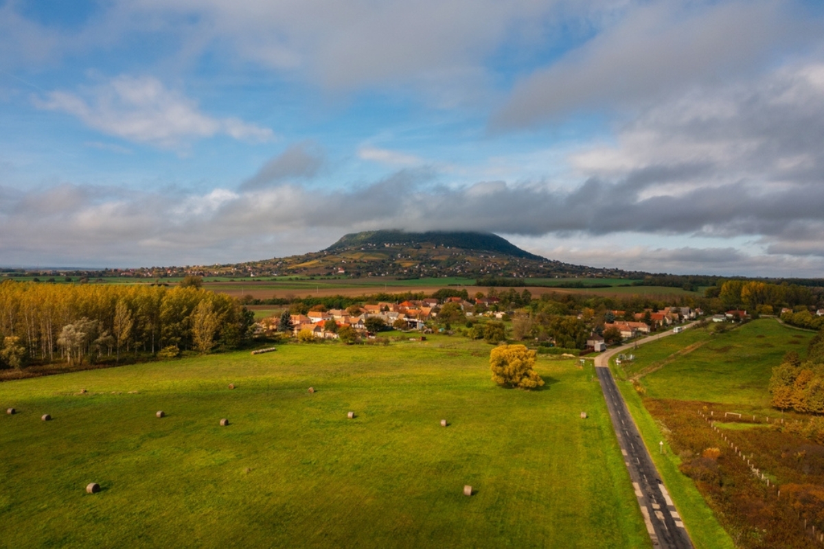 L'Altopiano del Balaton, in una giornata autunnale, con campi, un piccolo villaggio e la collina di Somlo in lontananza