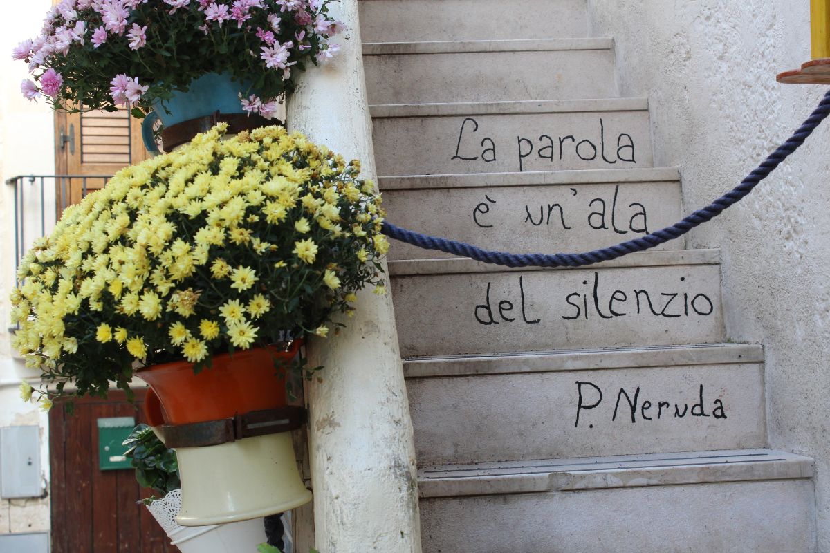 La poesia di Pablo Neruda citata sulle scale del villaggio di Polignano a Mare, uno dei numerosi interventi artistici di Guido Il Flâneur  
