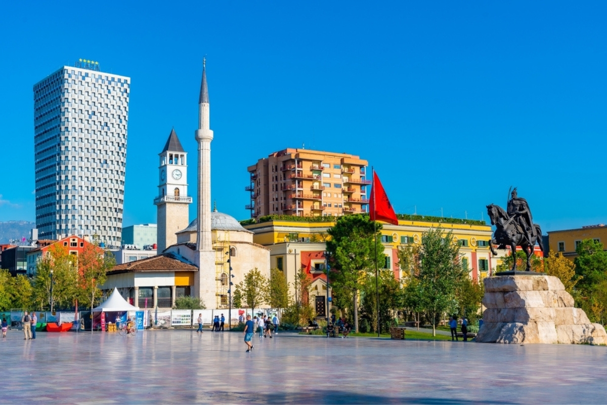 La gente passeggia davanti al monumento a Skanderbeg e alla moschea di Ethem Bey a Tirana, in Albania