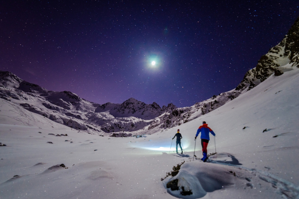 Two skiers engage in a romantic night skiing