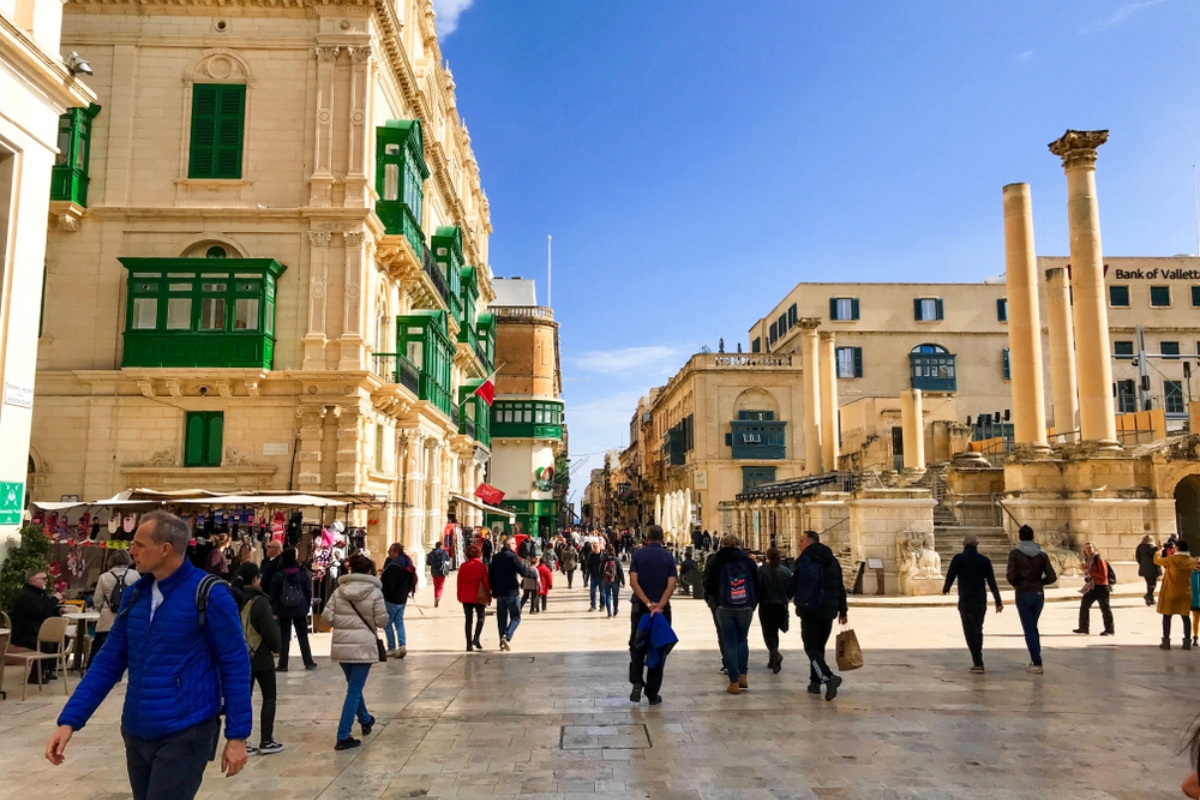 People walk around the city on a sunny winter morning in Valletta, Malta 