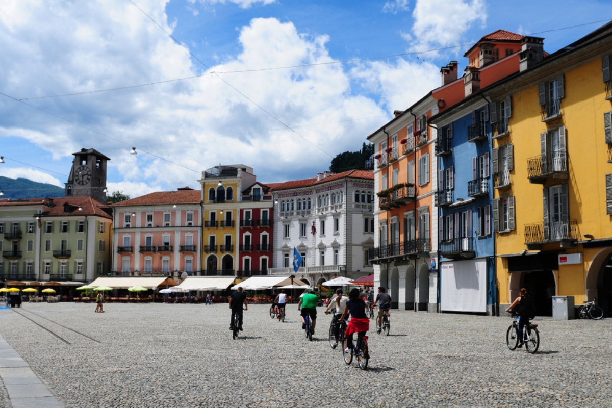 Persone in bicicletta nella bella Piazza Grande di Locarno, sul Lago Maggiore, Svizzera