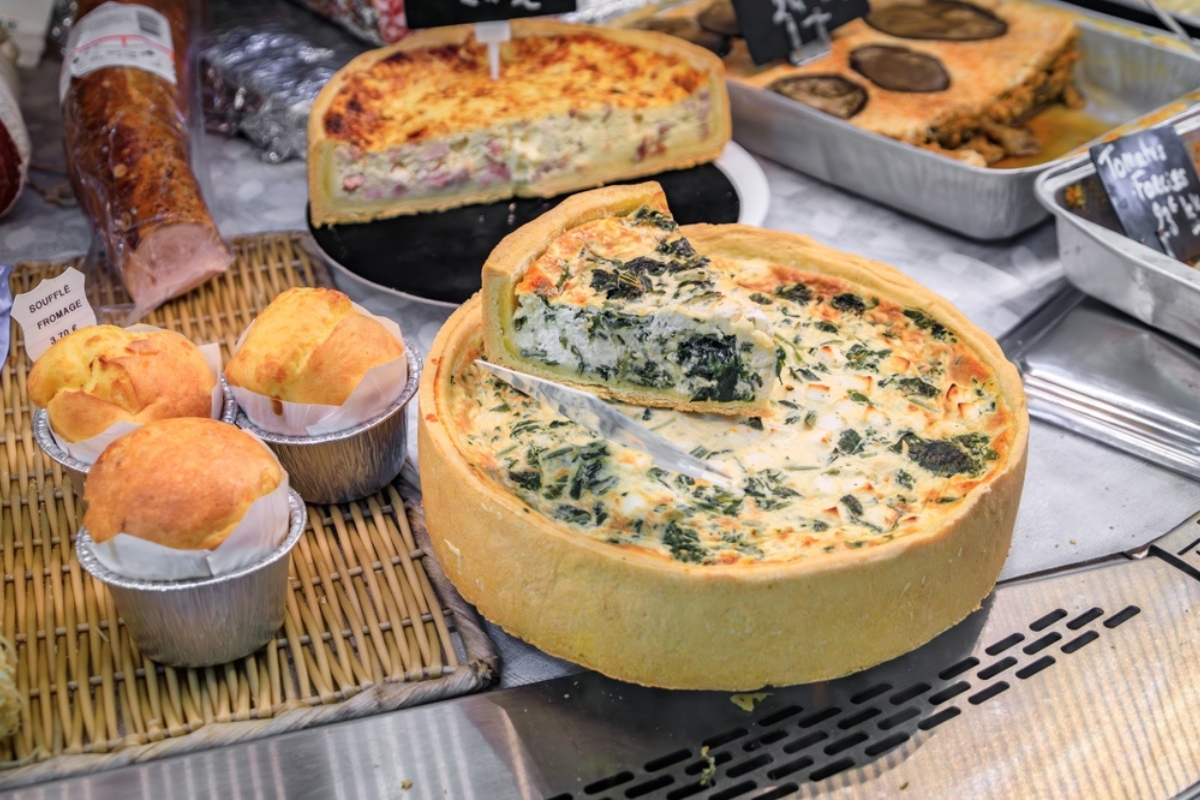 Quiche agli spinaci, quiche lorraine con prosciutto e formaggio, soufflé al formaggio al Marché des Halles di Mentone