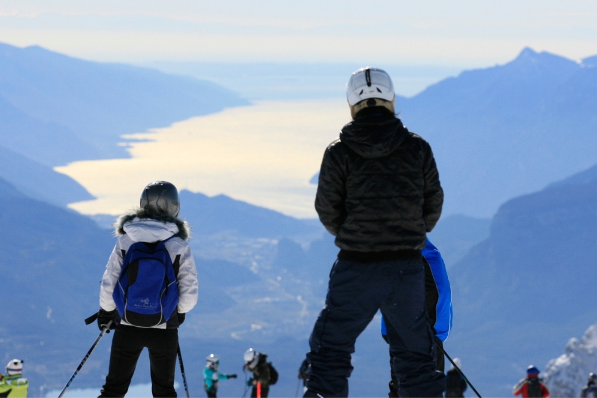 Ski season at the Paganella resort in Trentino South Tyrol, Andalo, Italy. Skiers in action in front of the Garda lake