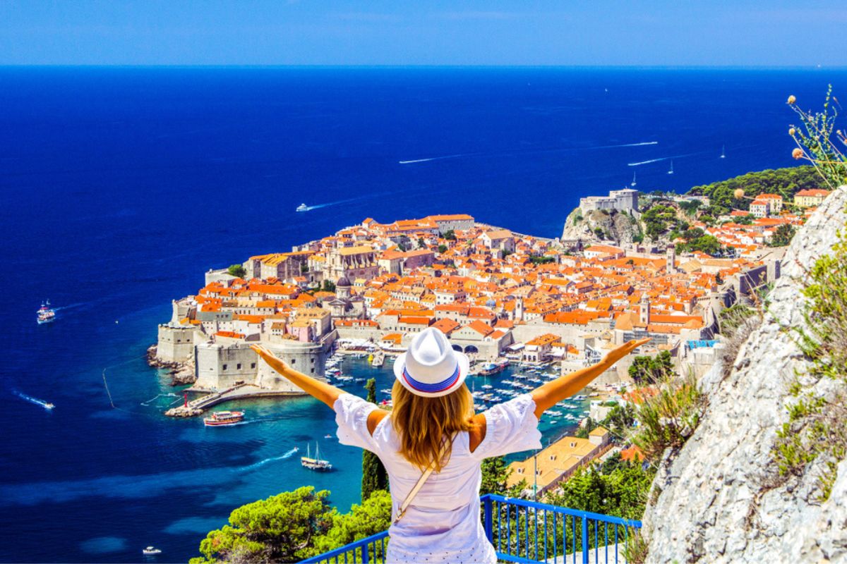 Una donna si gode la vista del centro storico (Dubrovnik medievale) e della costa dalmata del Mar Adriatico a Dubrovnik.