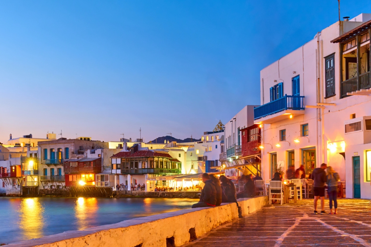 The Little Venice district with bars and restaurants by the sea in Mykonos island at dusk, Greece. Greek resort at night