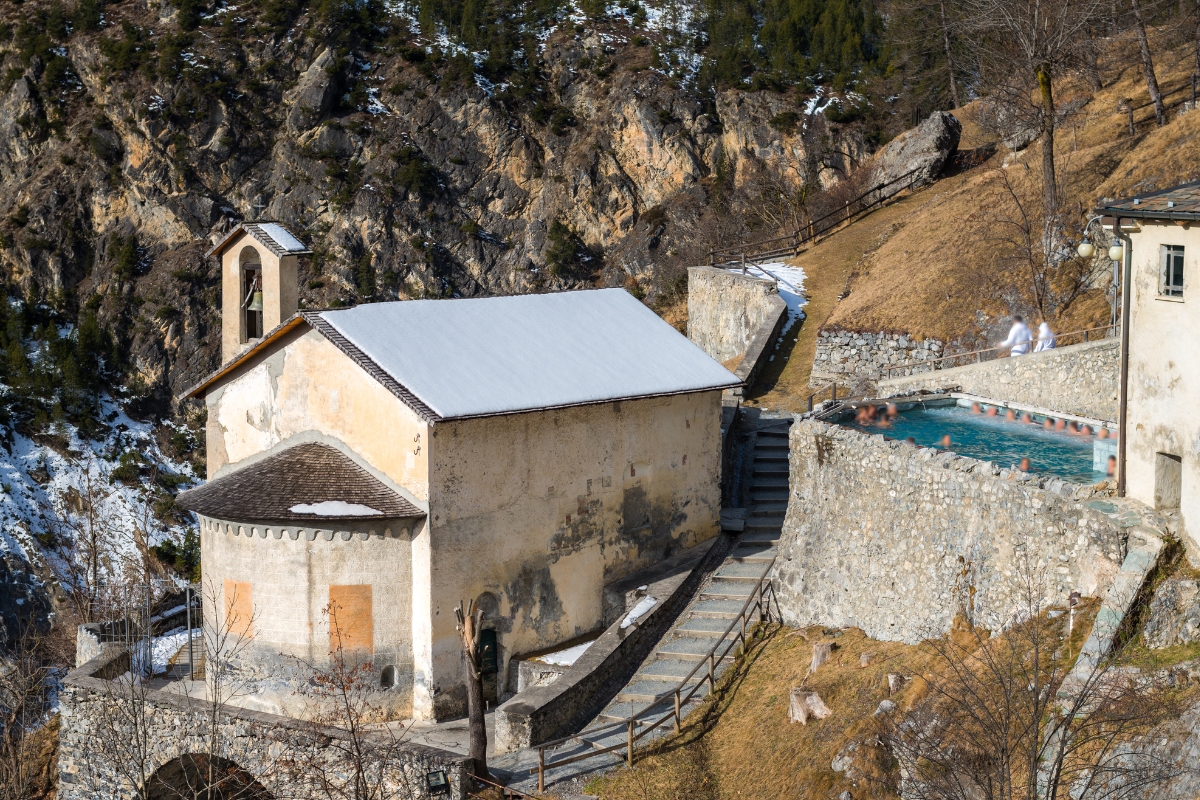 Outdoor thermal swimming pool and buildings at historic resort Bagni Vecchi in the Italian Alps