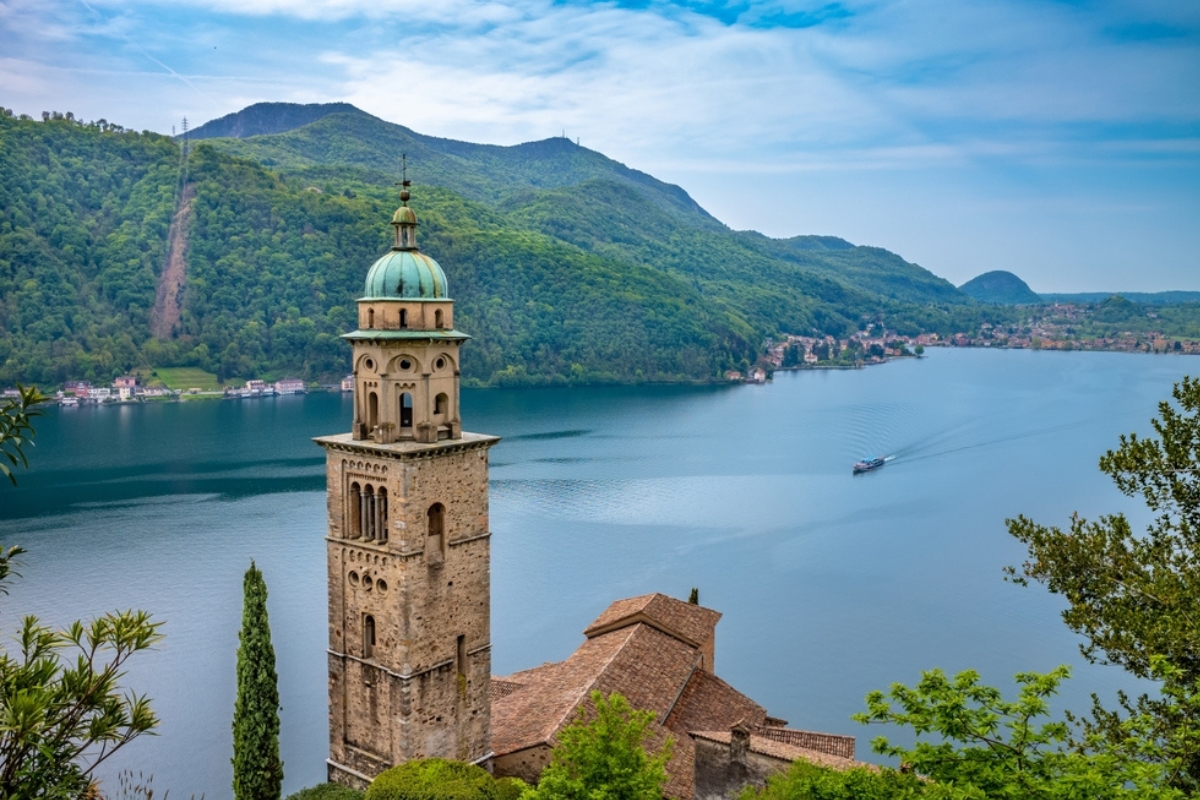 Landscape of Lake Lugano from Morcote village with the bell tower of the Santa Maria del Sasso church. Switzerland
