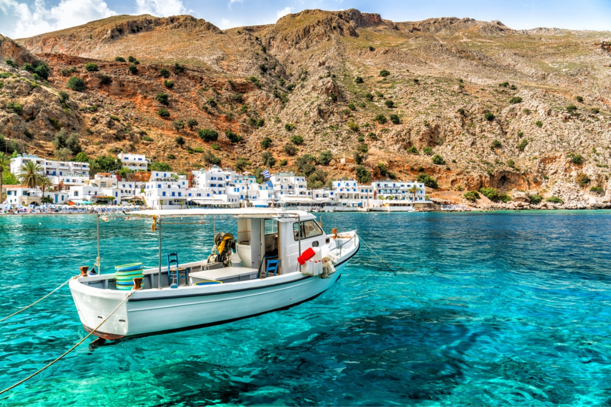 Un peschereccio nelle acque turchesi del villaggio di pescatori di Loutro, Creta, Grecia