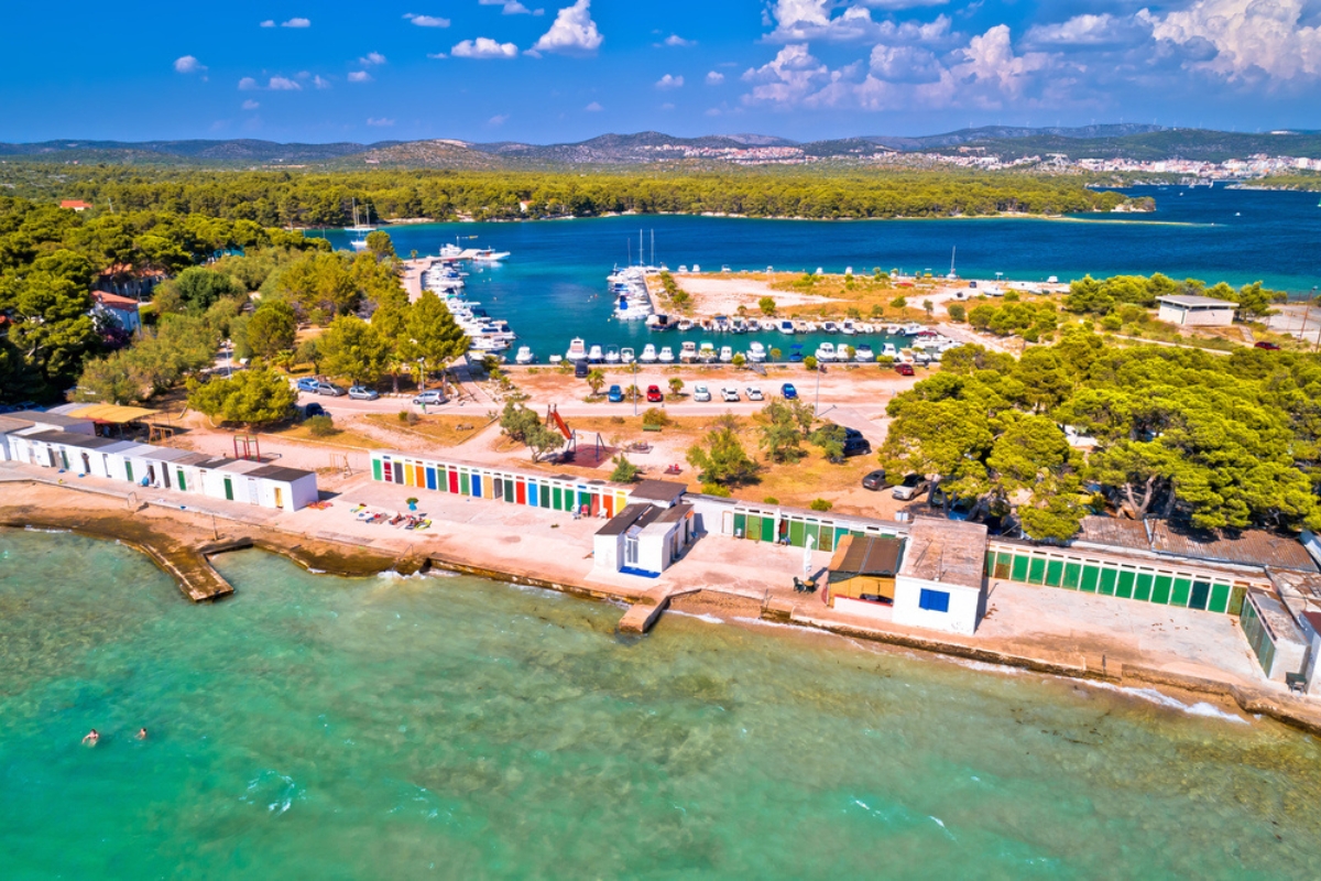 Veduta aerea della spiaggia di Jadrija a Sibenik, con le cabine colorate e l'acqua limpida dell'Adriatico