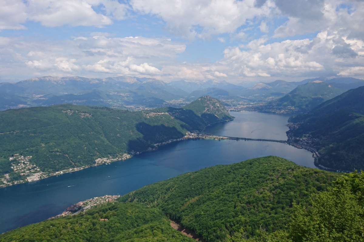 Meravigliosa vista sul Lago di Lugano e sulla città di Lugano dalla vetta del Monte San Giorgio nelle Alpi Lepontine in una giornata di primavera delicatamente avvolta da un mix di luci e ombre - Ticino - Svizzera